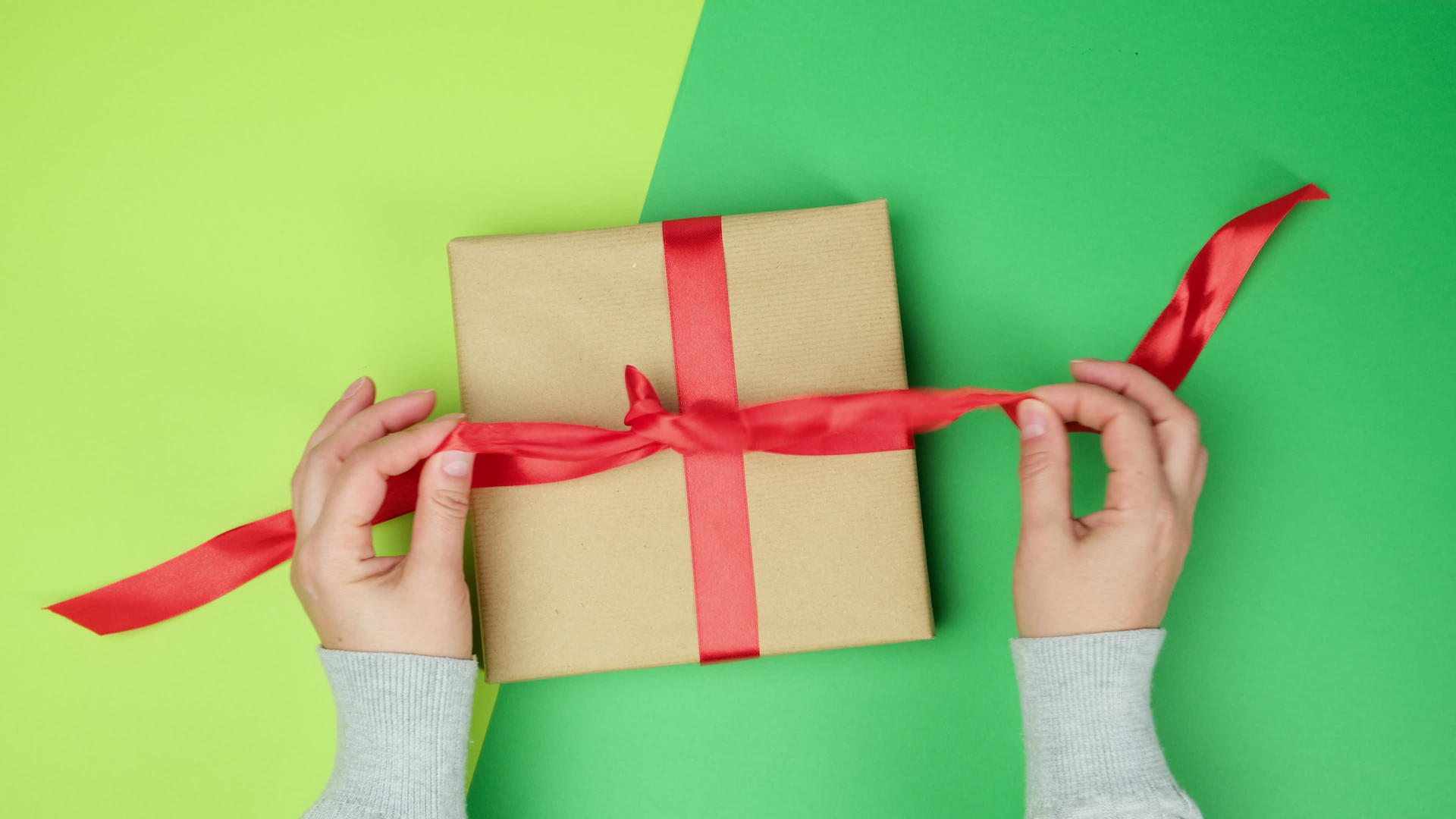 绿色背景礼品盒上的红色丝带视频的预览图
