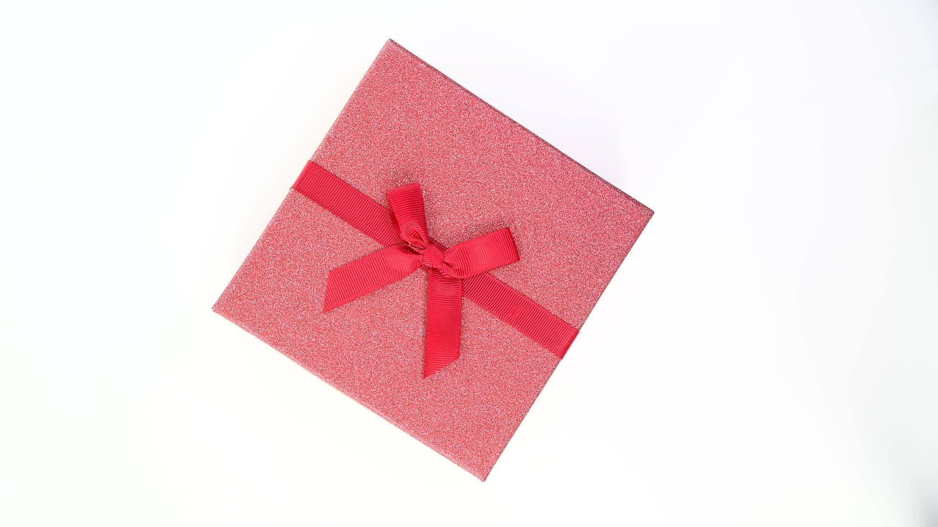 红色礼品盒的顶部视图在白色背景上穿过丝带视频的预览图