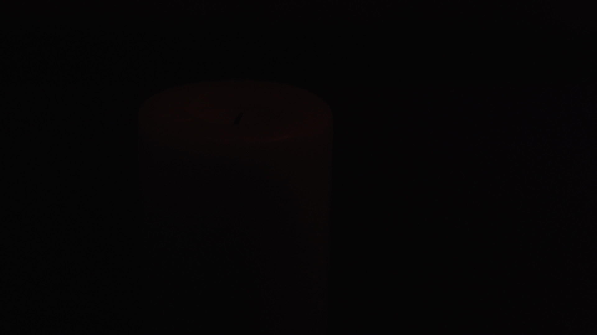 在低光下关闭蜡烛的镜头灯照亮了一会儿视频的预览图