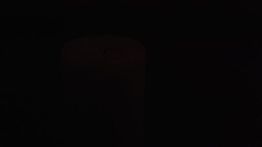 在低光下关闭蜡烛的镜头灯照亮了一会儿视频的预览图