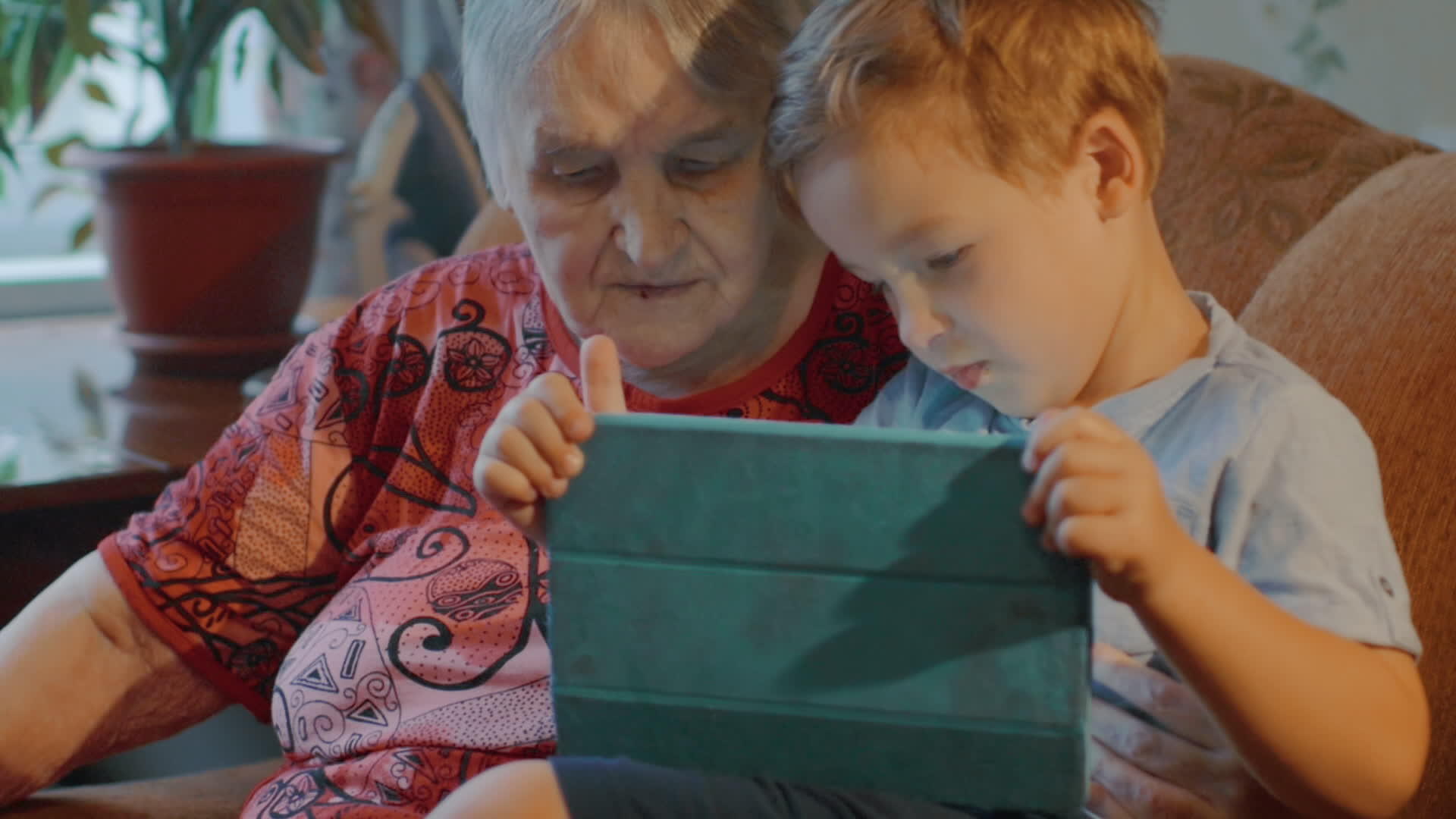 祖母和孙子在家使用平板药片视频的预览图