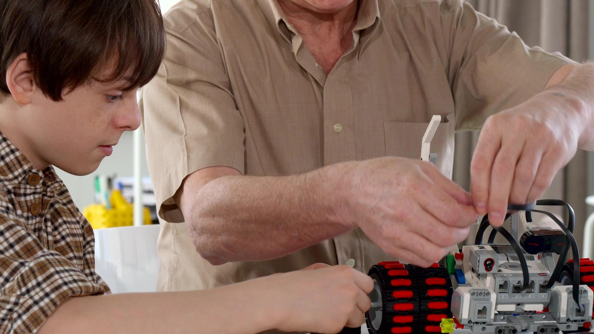 高级男子和孙子组装玩具车视频的预览图