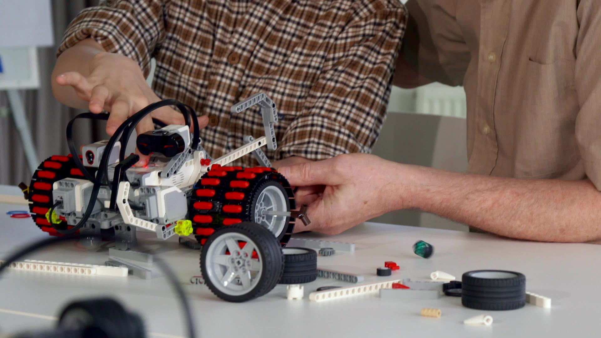 高级男子帮助孙子组装玩具车视频的预览图