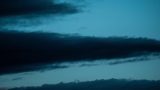 4kUHD满月在蓝色中穿过黑云在黎明中消失视频的预览图