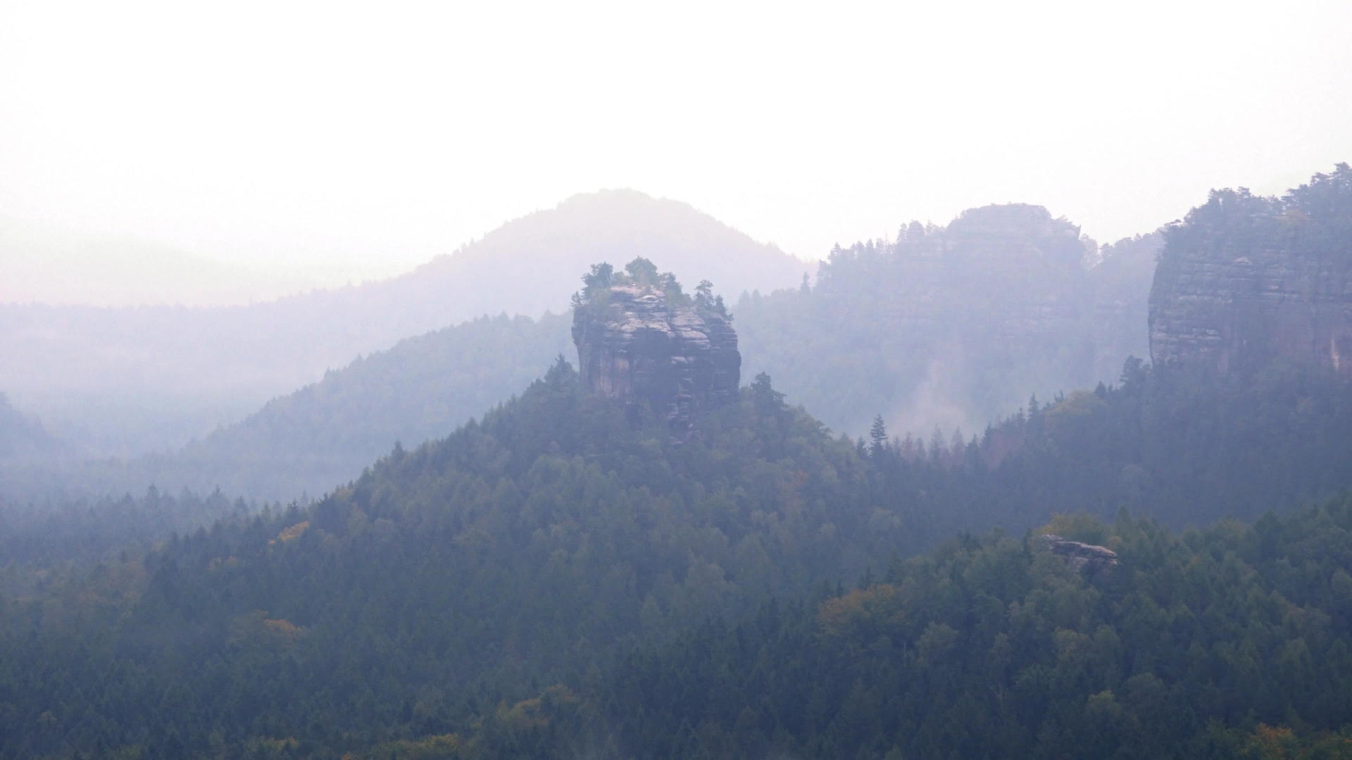 隐藏在山谷中的尖锐岩石充满了浓雾和雾视频的预览图