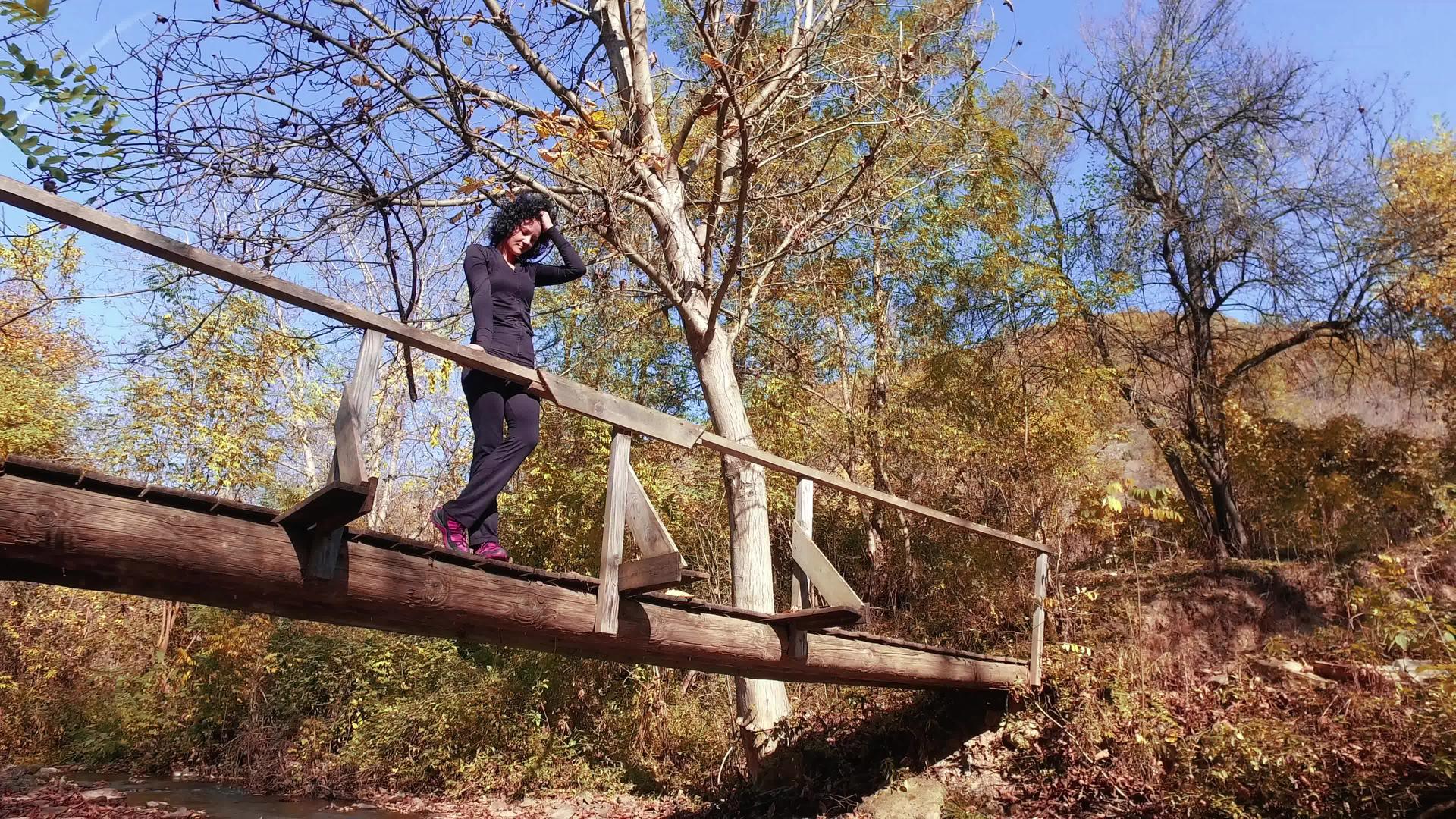 美丽的运动登山者享受秋天的风景站在树桥上微笑视频的预览图