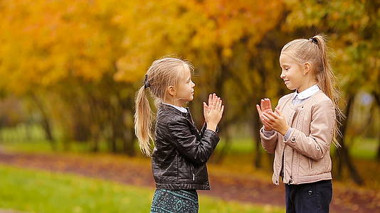 可爱的小女孩在秋天公园的温暖日子里玩得很开心视频的预览图