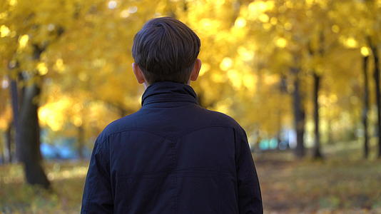秋天公园里年轻人穿着黑色外套的视频被拍了下来视频的预览图