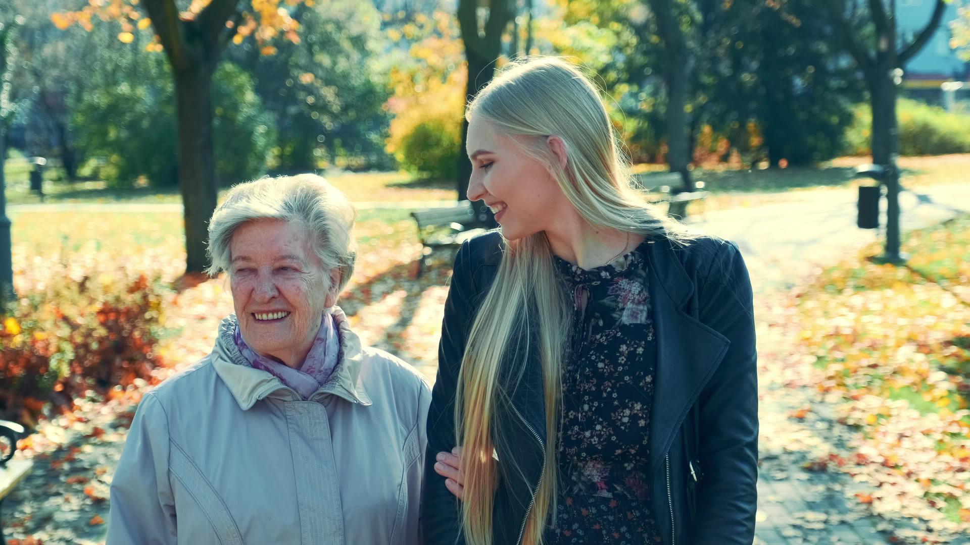 在公园里散步时老妇人和美丽的年轻女子互相拥抱视频的预览图