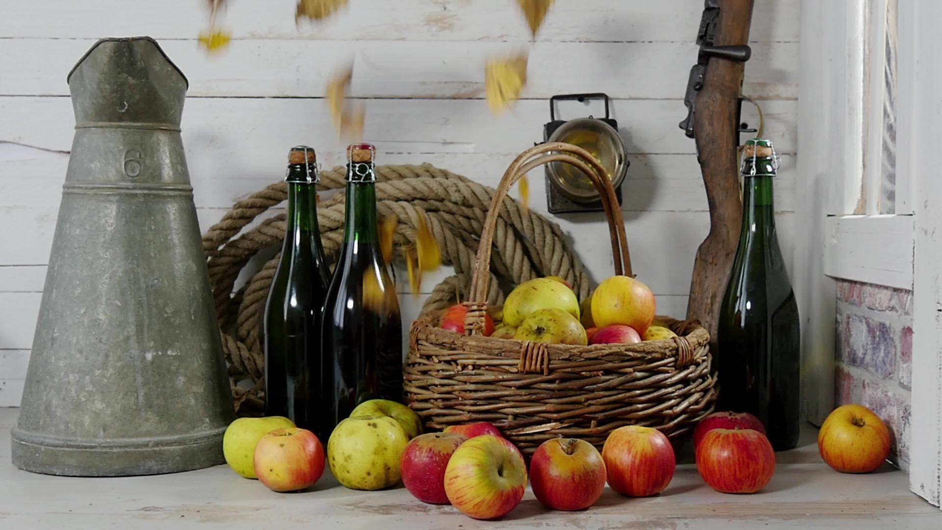 秋天的黄叶落在苹果和一瓶苹果酒上视频的预览图
