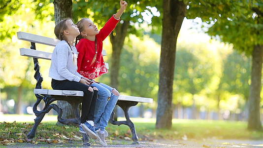 可爱的小女孩在阳光明媚的秋天在户外玩得很开心孩子们都很开心视频的预览图