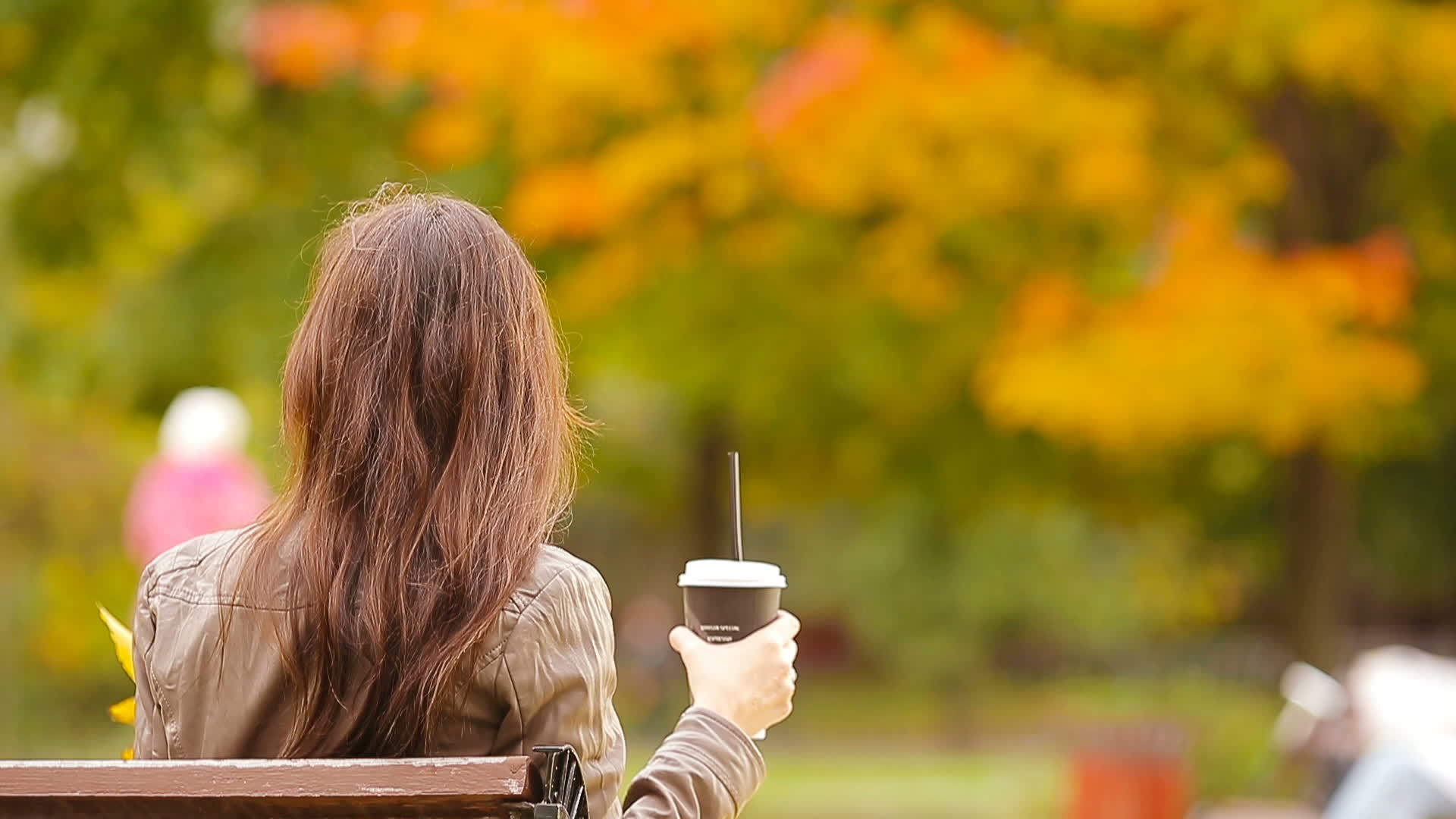 秋天在公园里喝咖啡的美丽女人视频的预览图