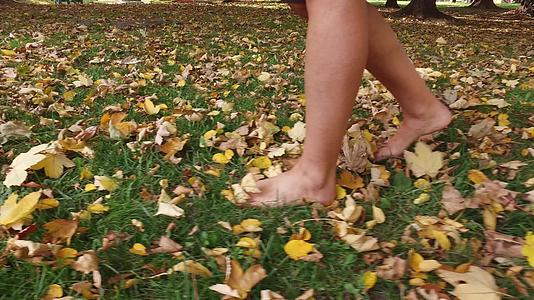 秋天女人赤脚穿黑色靴子在落叶上穿黑色靴子k视频的预览图