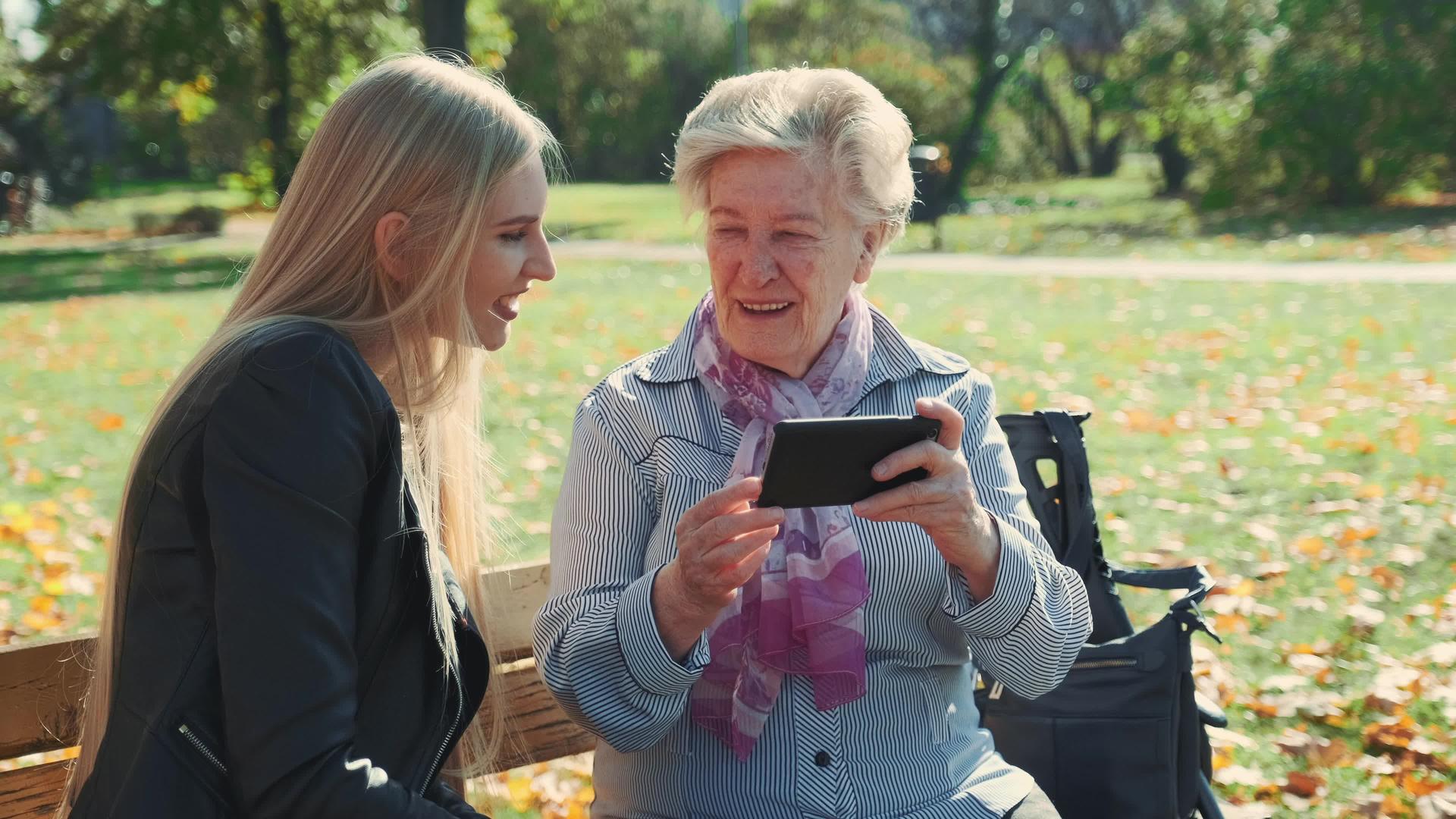 大奶奶在智能手机上展示孙女的照片请看她孙女的照片视频的预览图