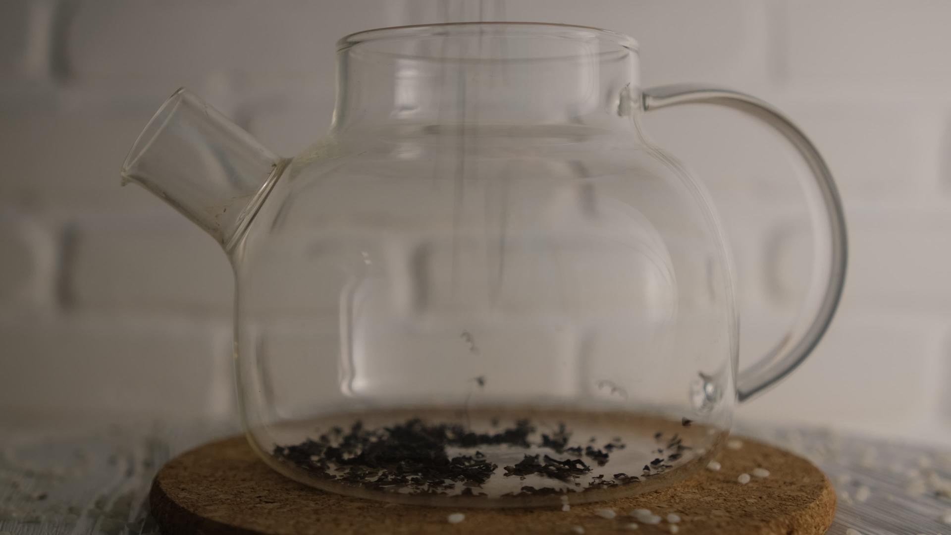 将红茶倒入玻璃茶壶白砖模糊背景旋转头晕灯视频的预览图