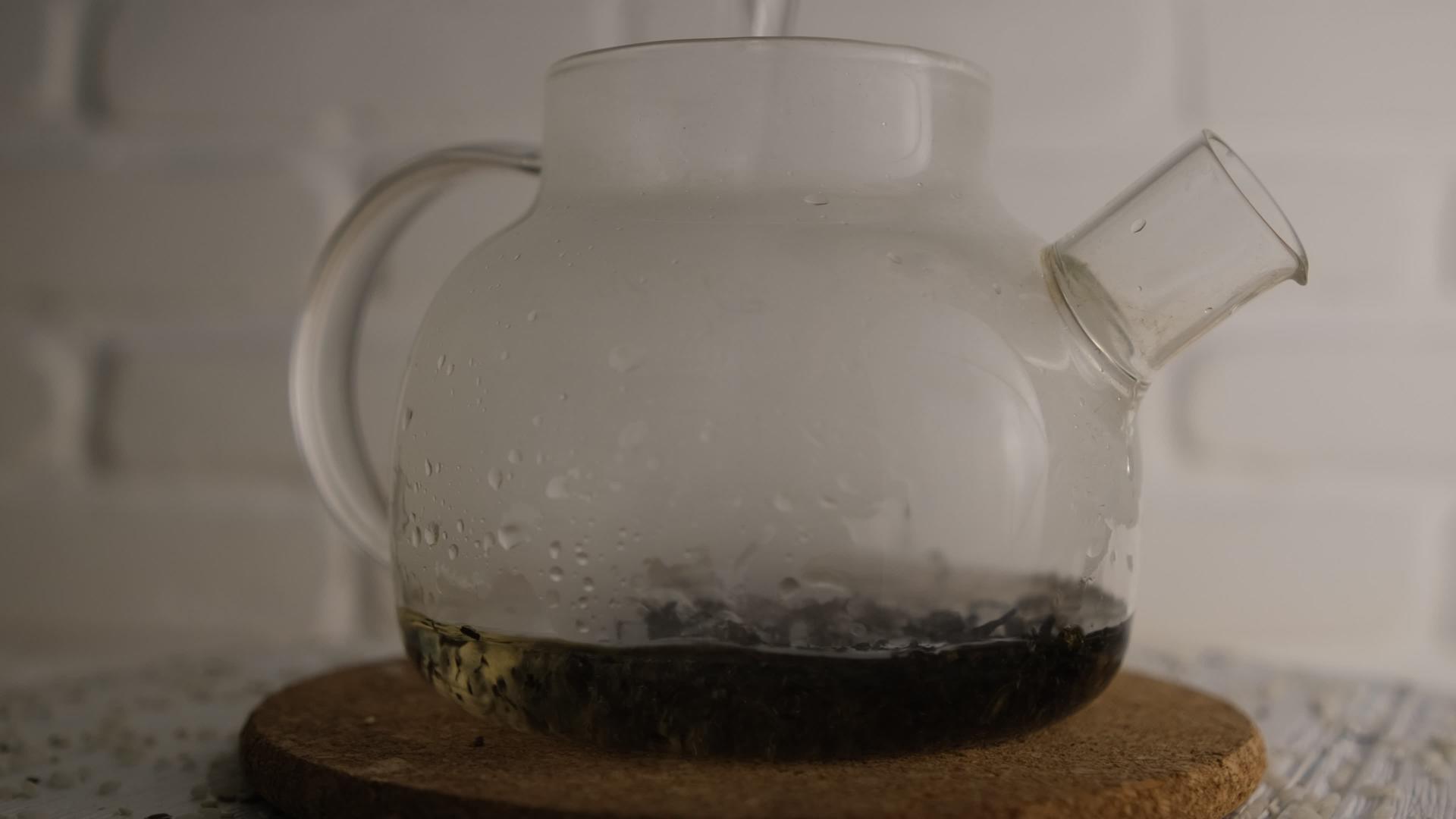 将沸水倒在红茶壶的红茶上白砖模糊背景旋转头晕灯视频的预览图