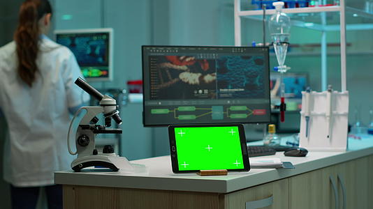 在实验室工作的带有绿色屏幕的笔记本电脑配备了模拟监视器视频的预览图