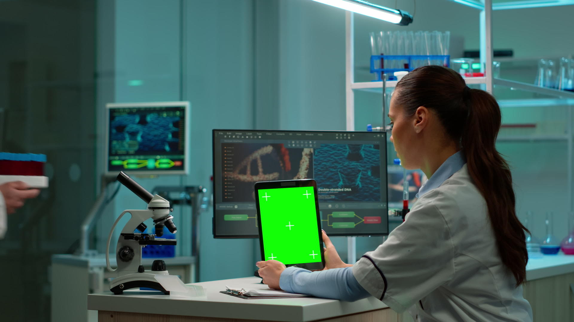 化学家科学家坐在办公桌前使用绿色模拟屏幕平板电脑视频的预览图