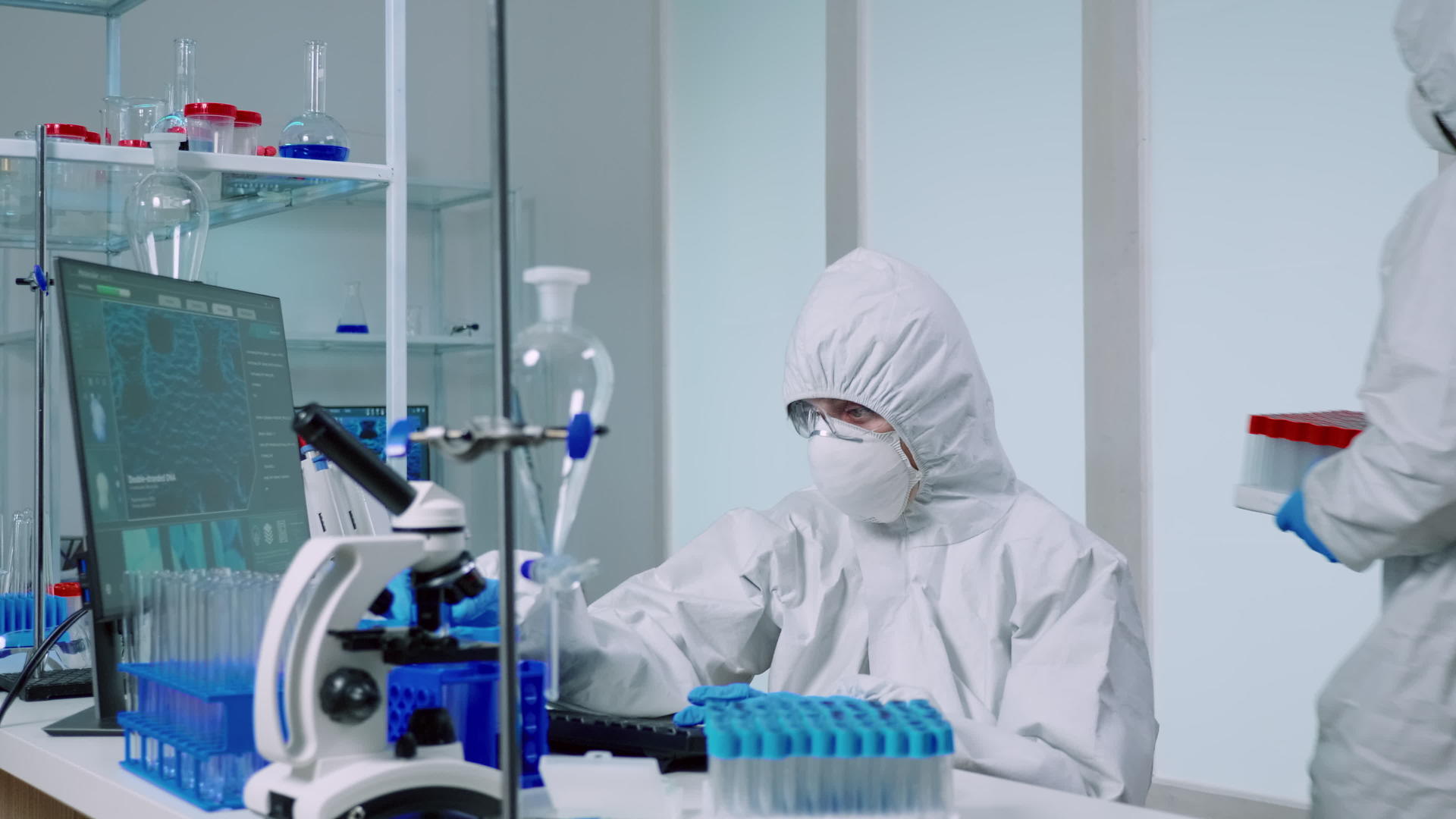 实验室里有覆盖物的科学家用蓝色液体进行测试视频的预览图