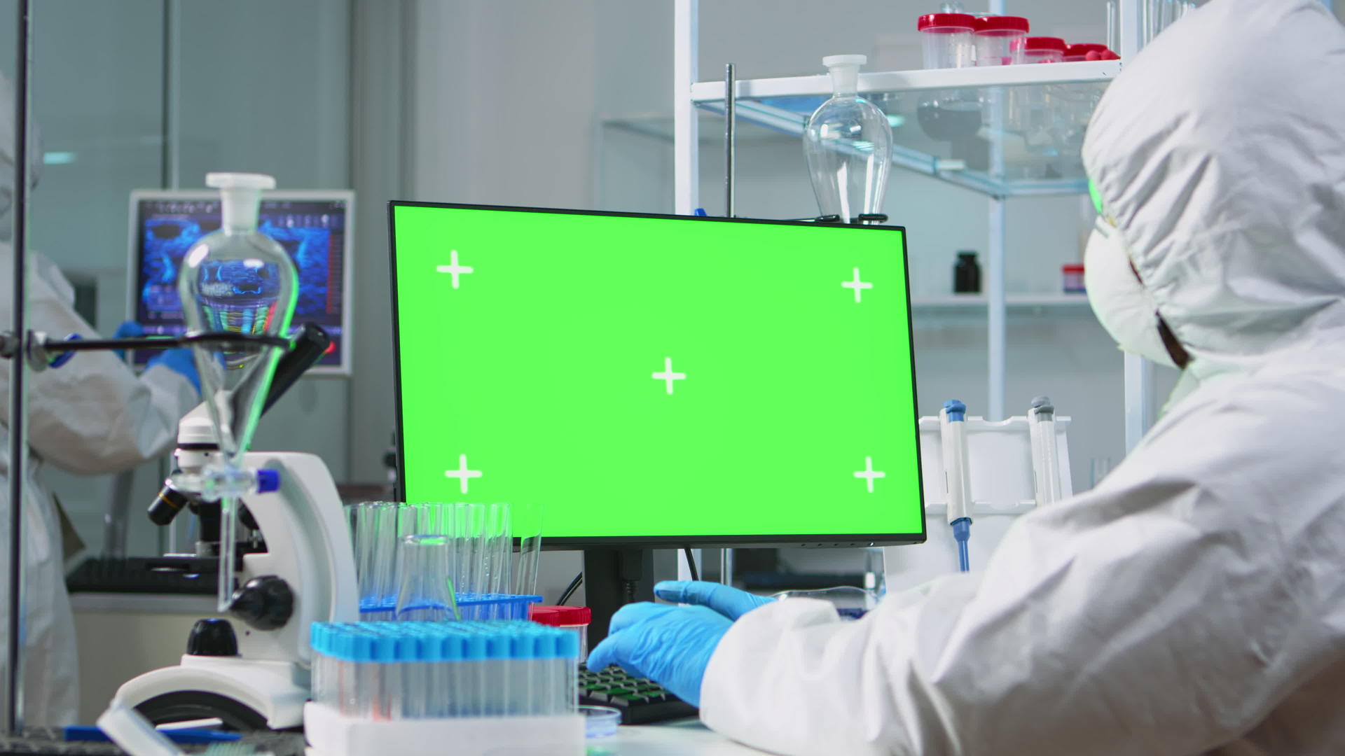 穿着防护服的医生在绿色模型计算机上打字视频的预览图
