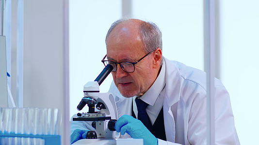 高级实验室技术高级技术人员使用显微镜检查样品和液体视频的预览图