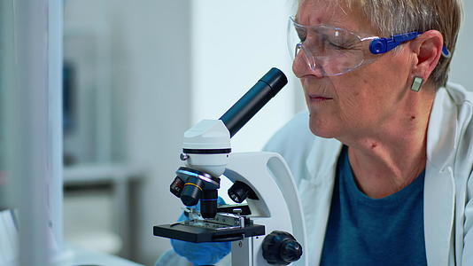 女性研究科学家在近距离观察显微镜下的样本视频的预览图