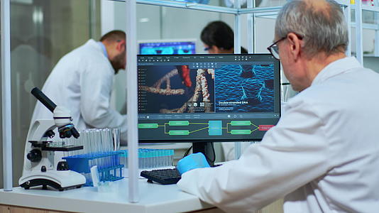 科学家穿着实验室外套在实验室的电脑前工作视频的预览图