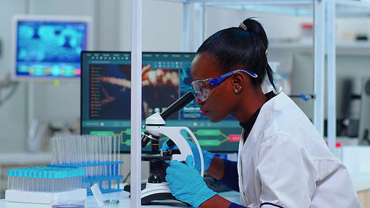 非洲女性生物化学家在实验室使用显微镜视频的预览图