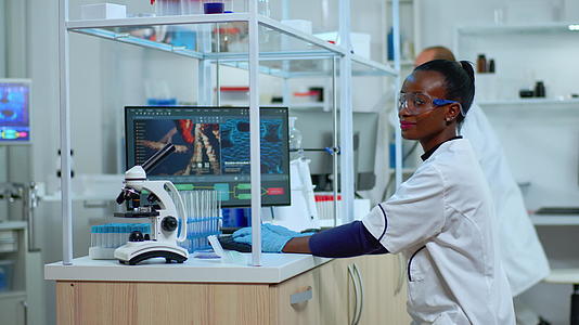 在现代设备齐全的实验室工作时非洲女医生微笑着拍照视频的预览图