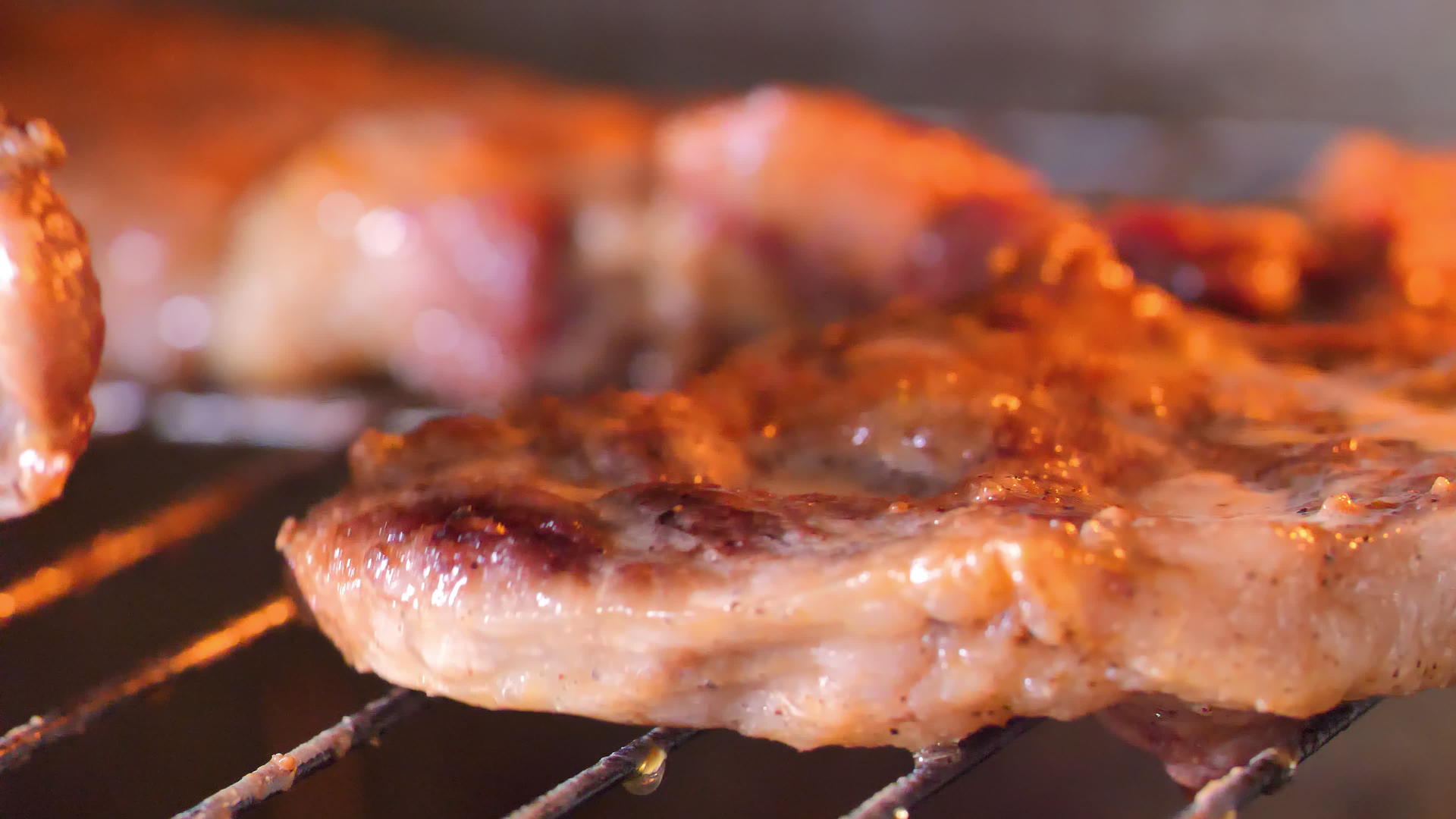 把烤猪肉翻过烤箱的烤架视频的预览图