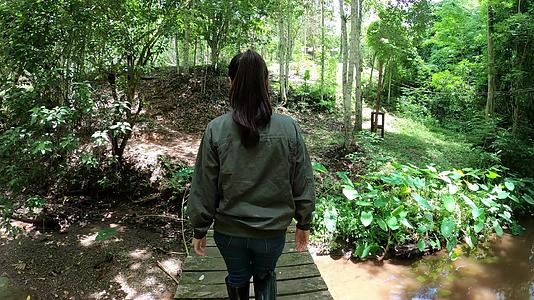 妇女在森林的木桥上行走视频的预览图