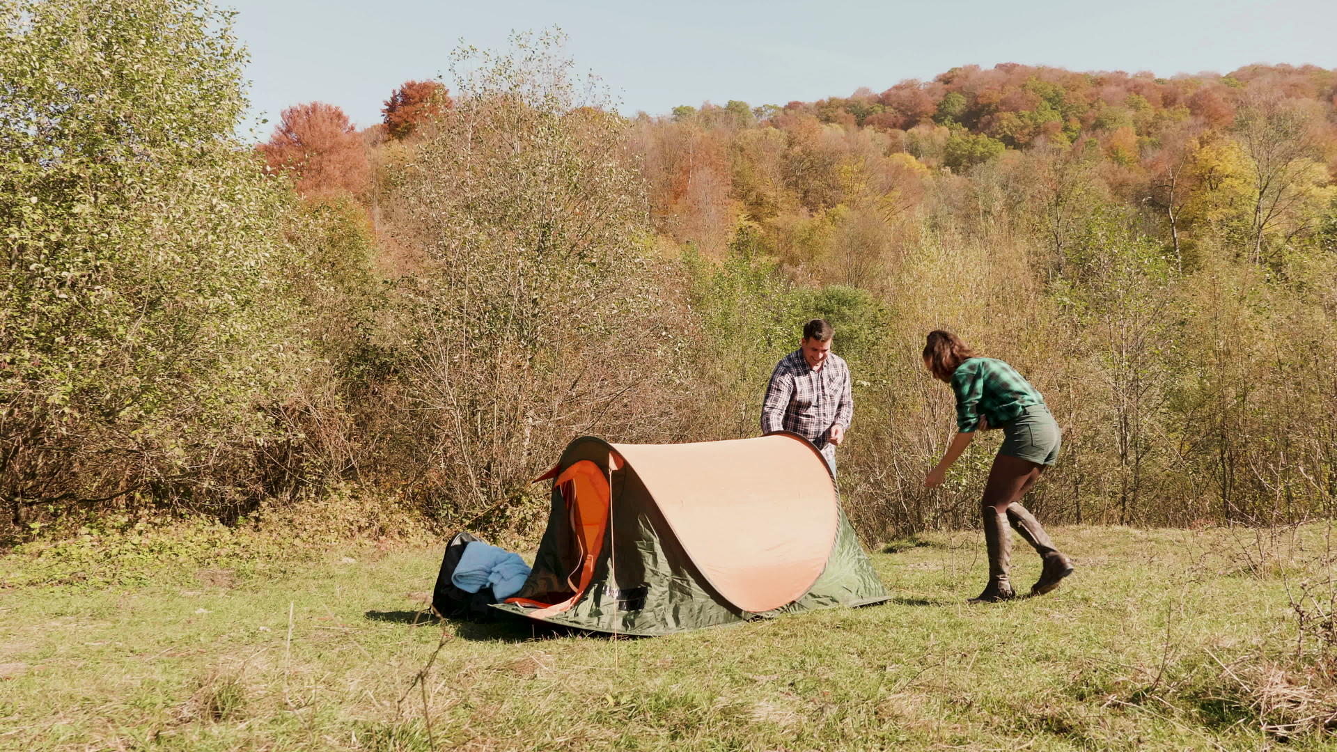 年轻夫妇互相帮助建造露营帐篷视频的预览图