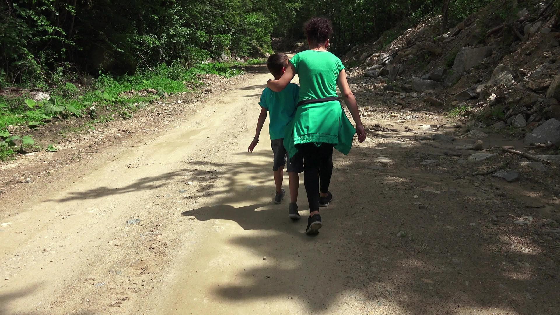 健康家庭生活兄弟姐妹在农村公路上徒步旅行拥抱在一起视频的预览图