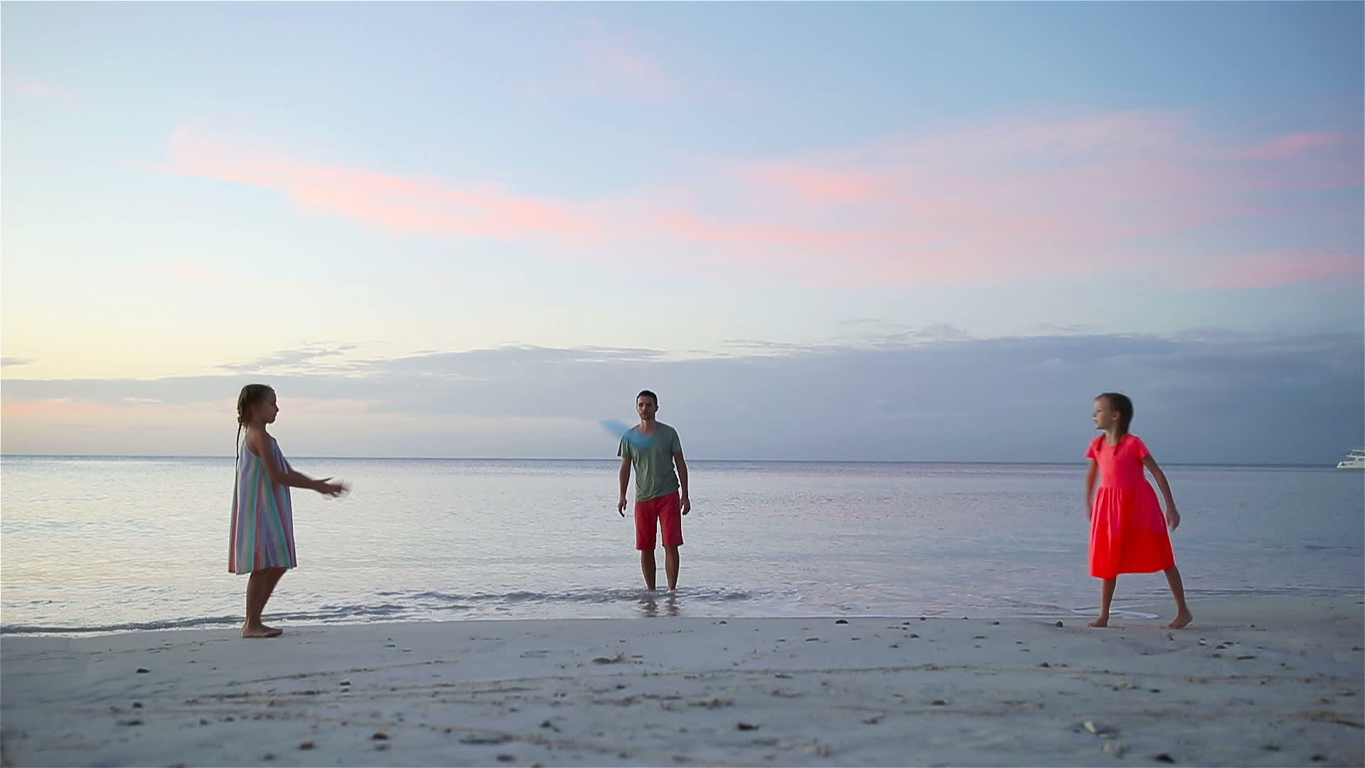 快乐的家庭在日落的海滩上玩飞盘游戏视频的预览图