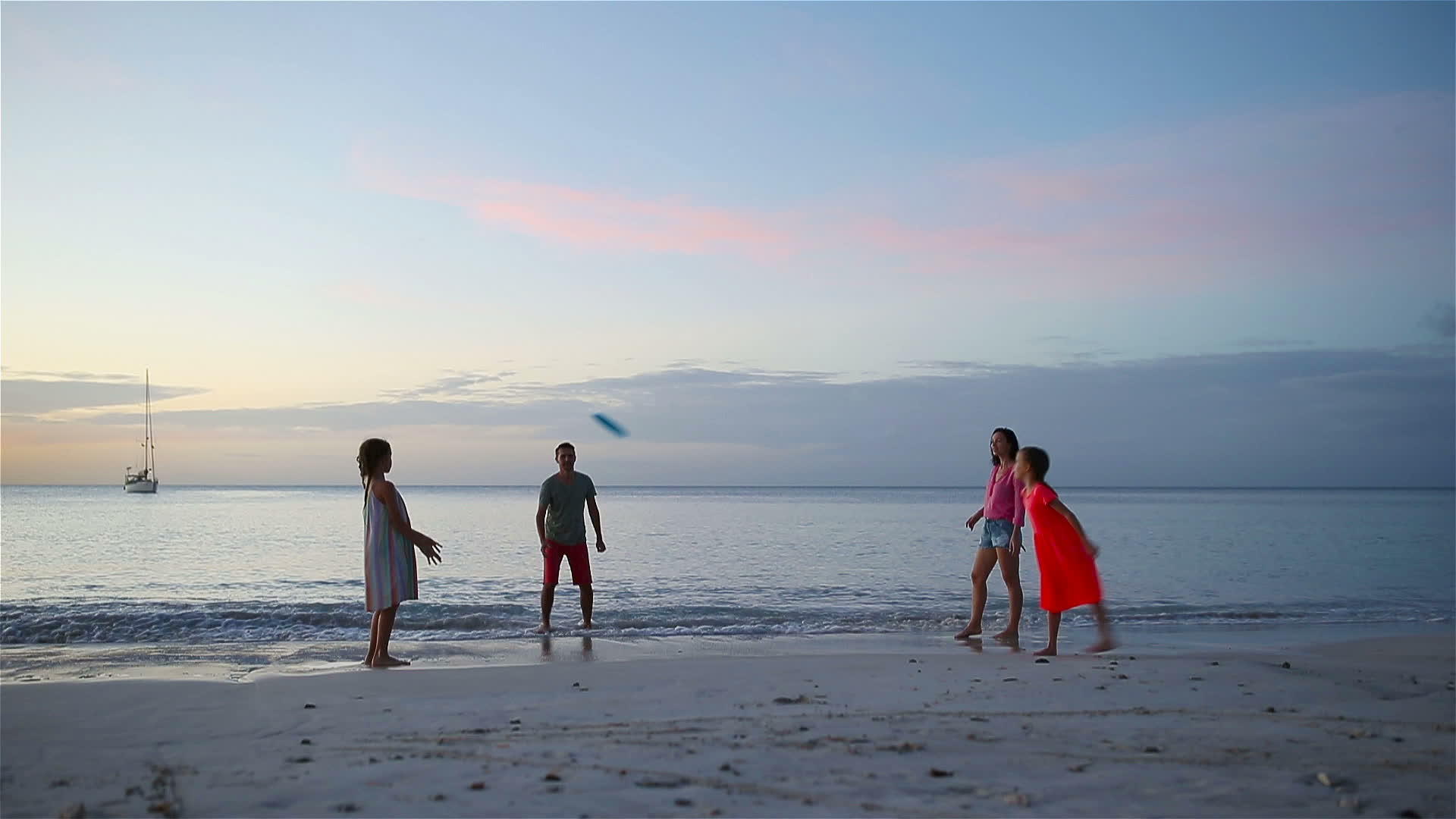 快乐的家庭在日落的海滩上玩飞盘游戏视频的预览图