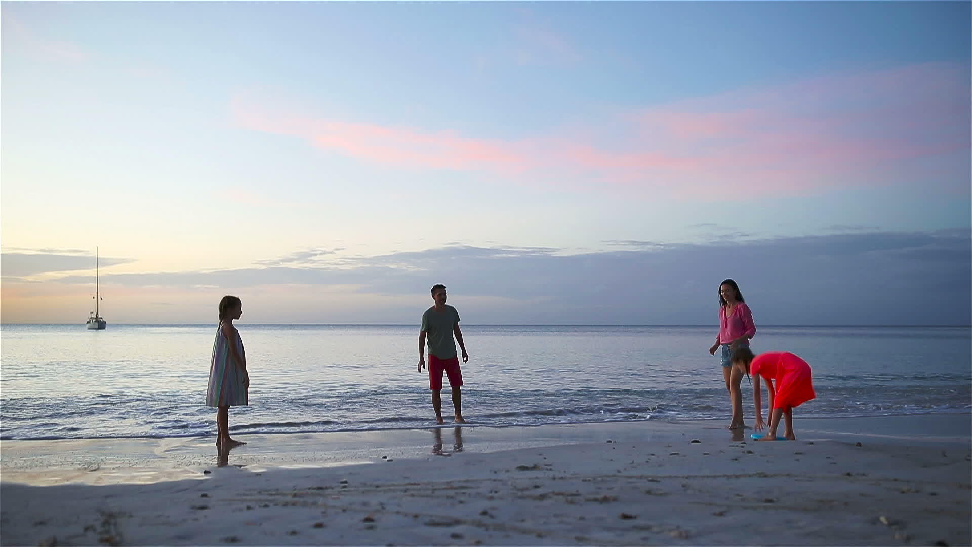 一个四口之口的幸福家庭在沙滩上一起玩耍视频的预览图