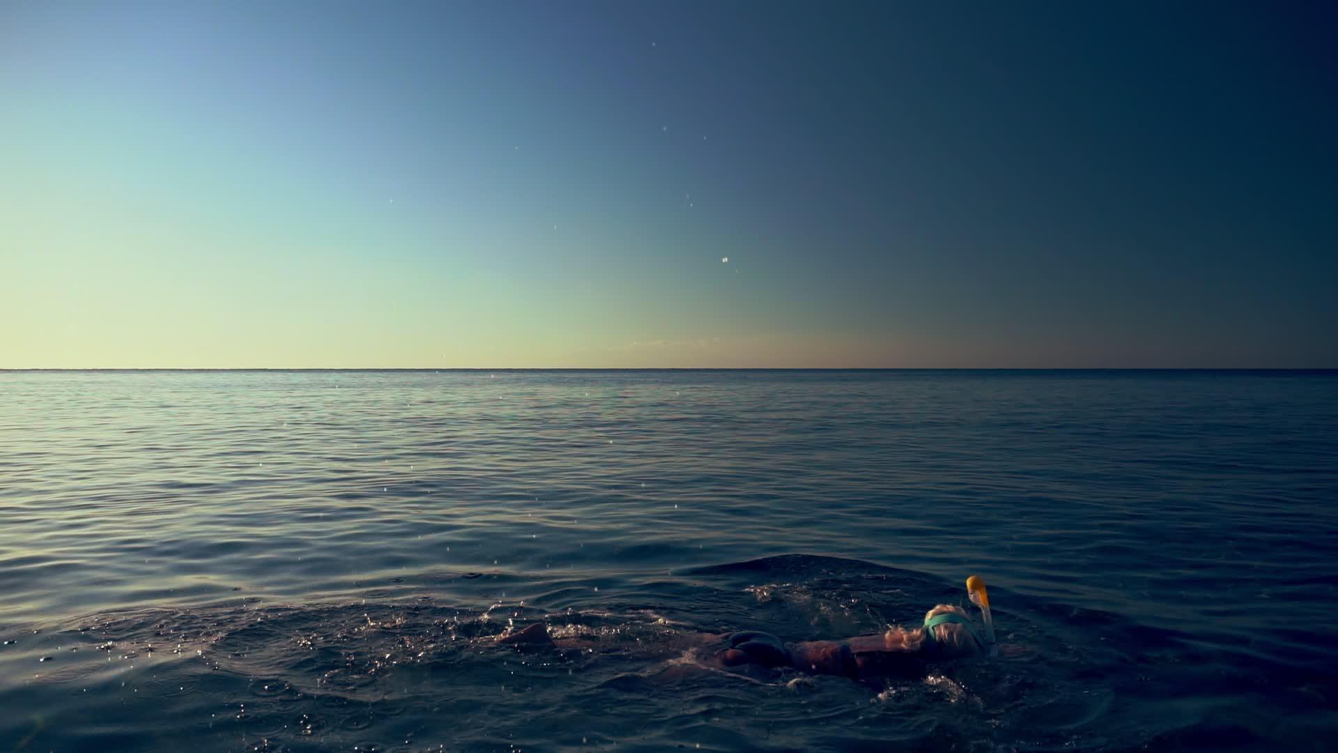 女人漂浮在海面上俯冲在礁石上视频的预览图