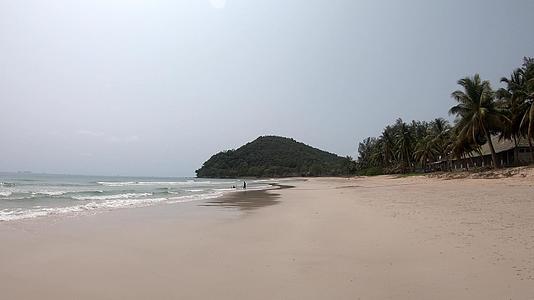 观光师在沙滩和浅波中的背景树ThungwuaLaen视频的预览图
