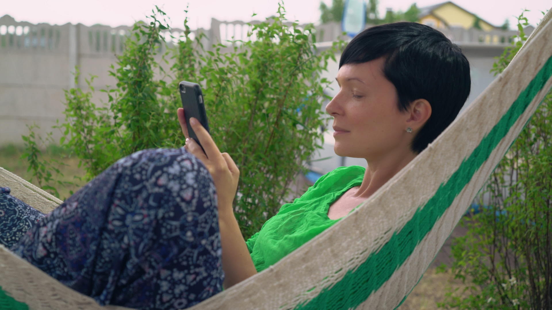 黑发短发女性在户外使用智能手机视频的预览图