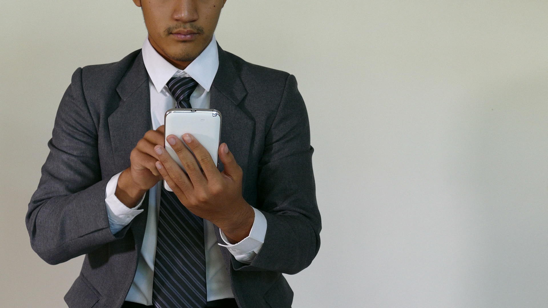 年轻的企业家和商人使用白色背景移动智能手机-商人视频的预览图