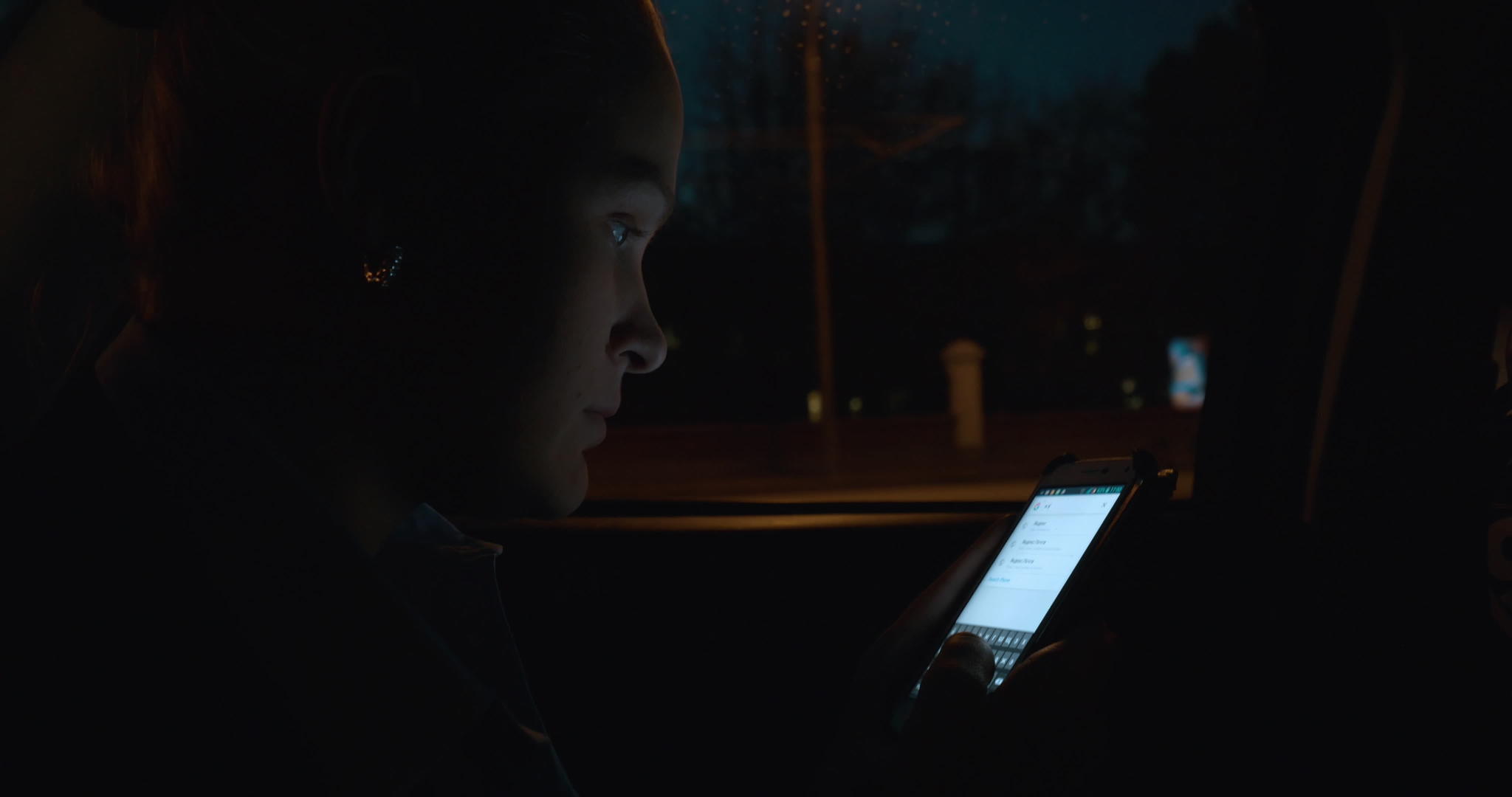 晚上女性在车里使用智能手机视频的预览图