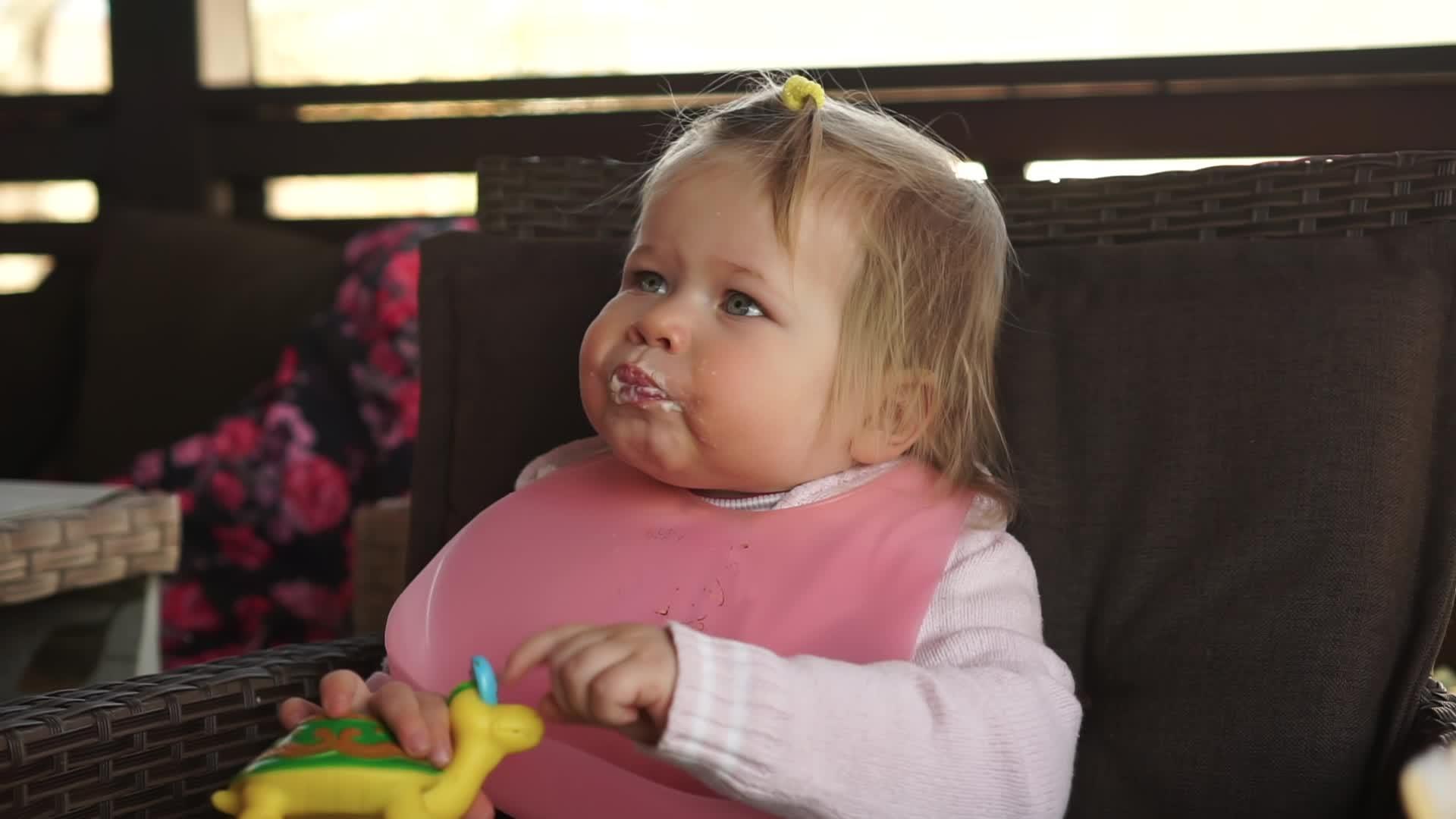 一个一岁的胖女婴在瞪羚区喂食和吃东西视频的预览图