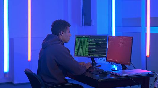 非洲年轻人非洲年轻人在黑暗的房间里写黑客程序视频的预览图
