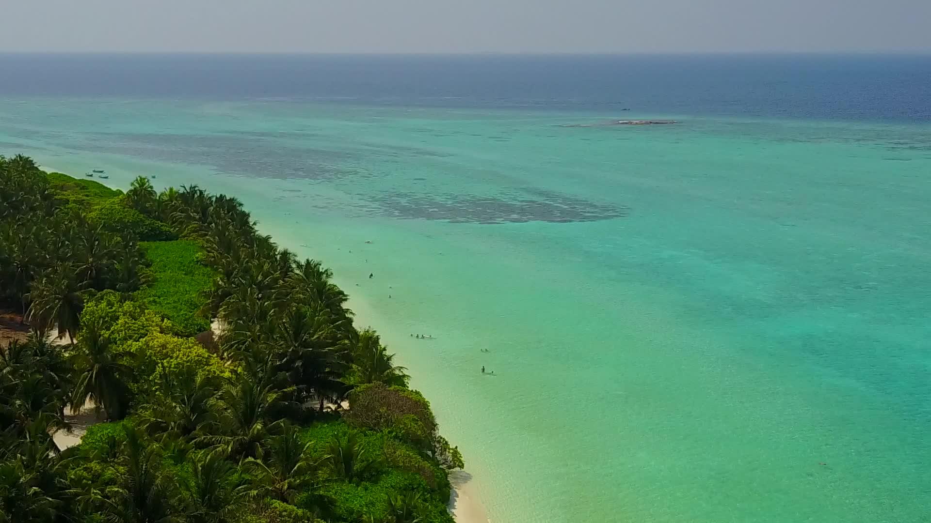 通过透明的海洋和平静的岛屿海滩时间的白色海滩背景视频的预览图