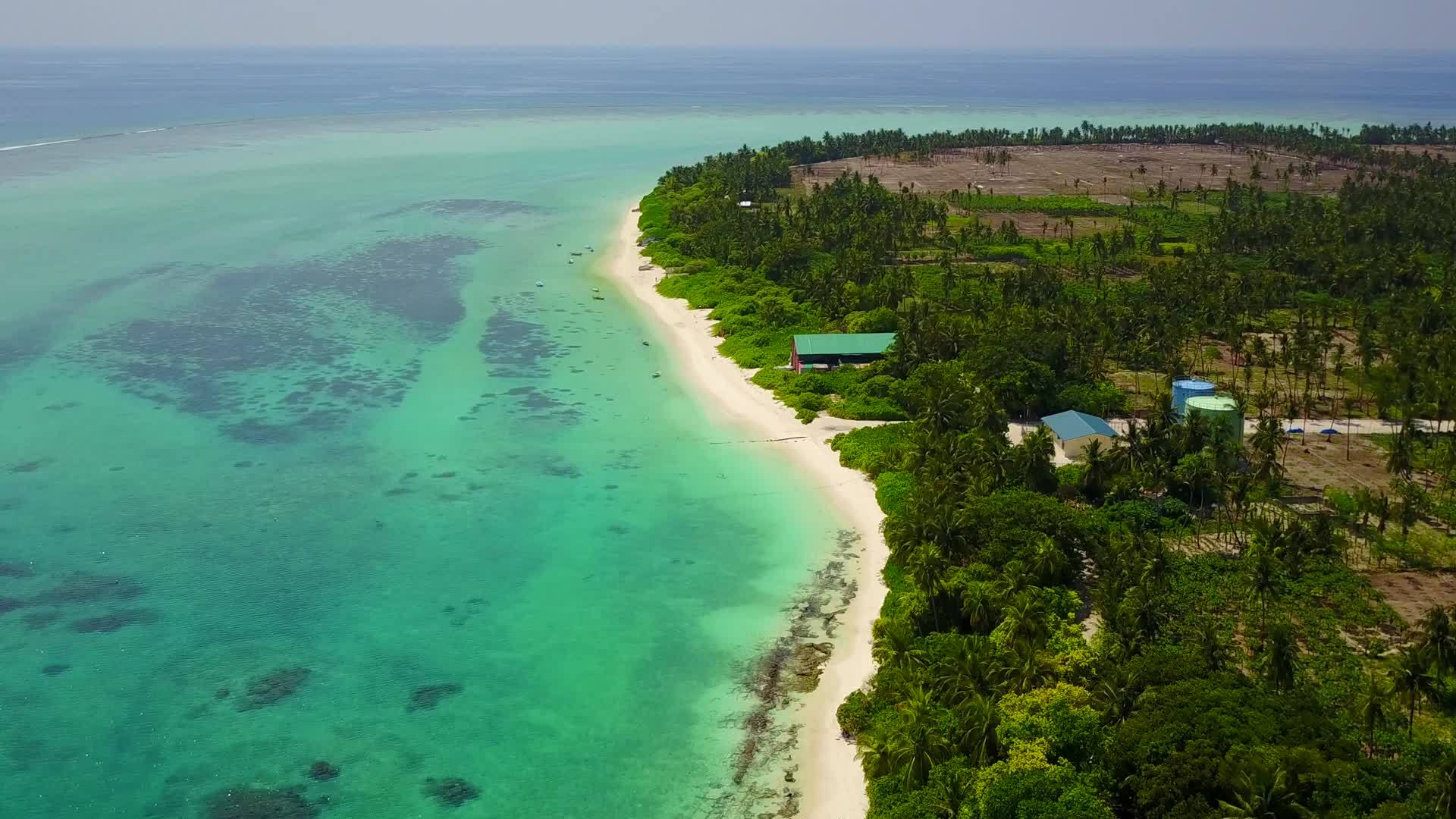 热带环礁湖海滩以白色沙滩为背景的蓝海航行视频的预览图