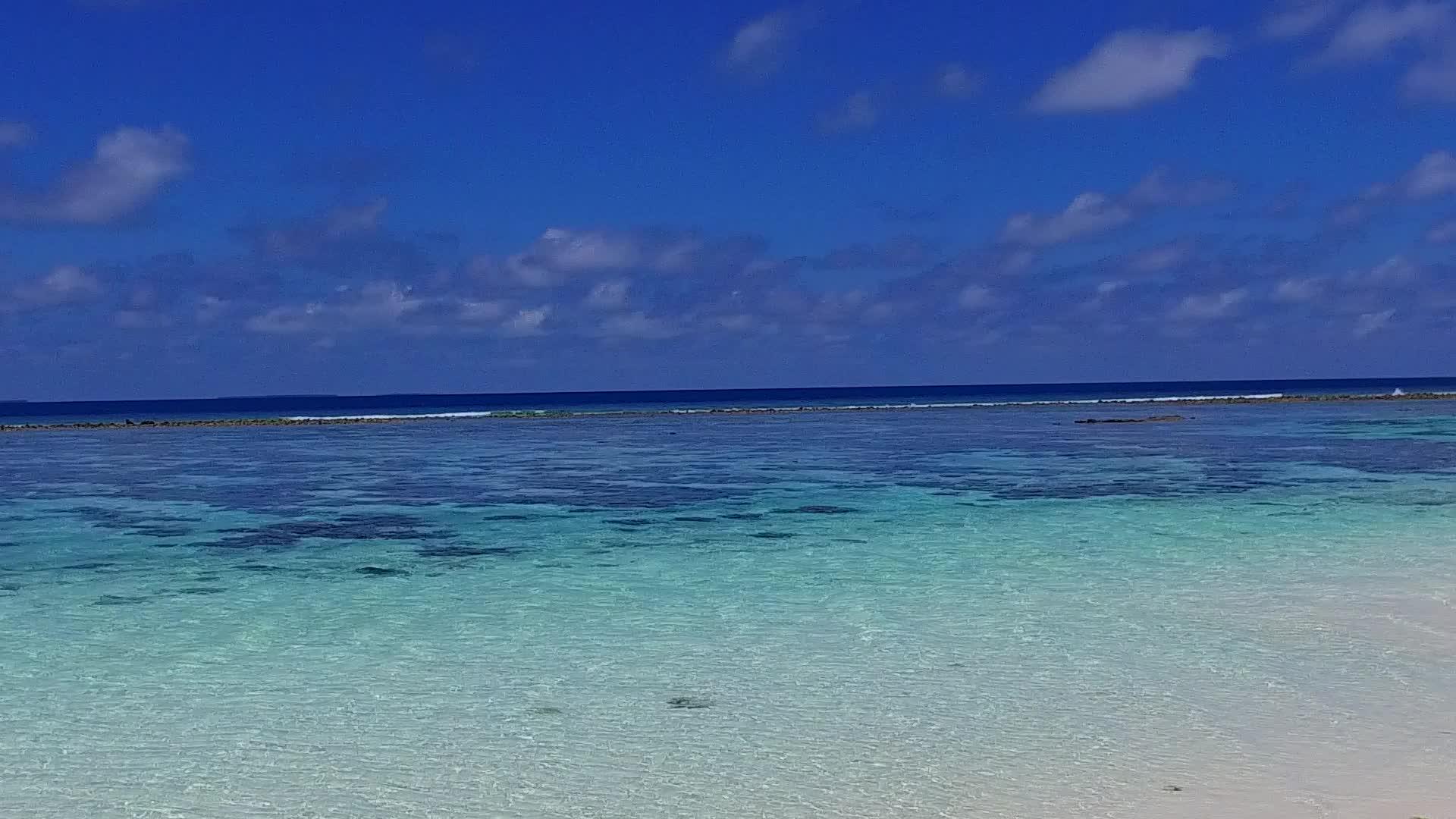 以清沙为背景的蓝色海洋突破了海岸海滩完美的海岸线全景视频的预览图