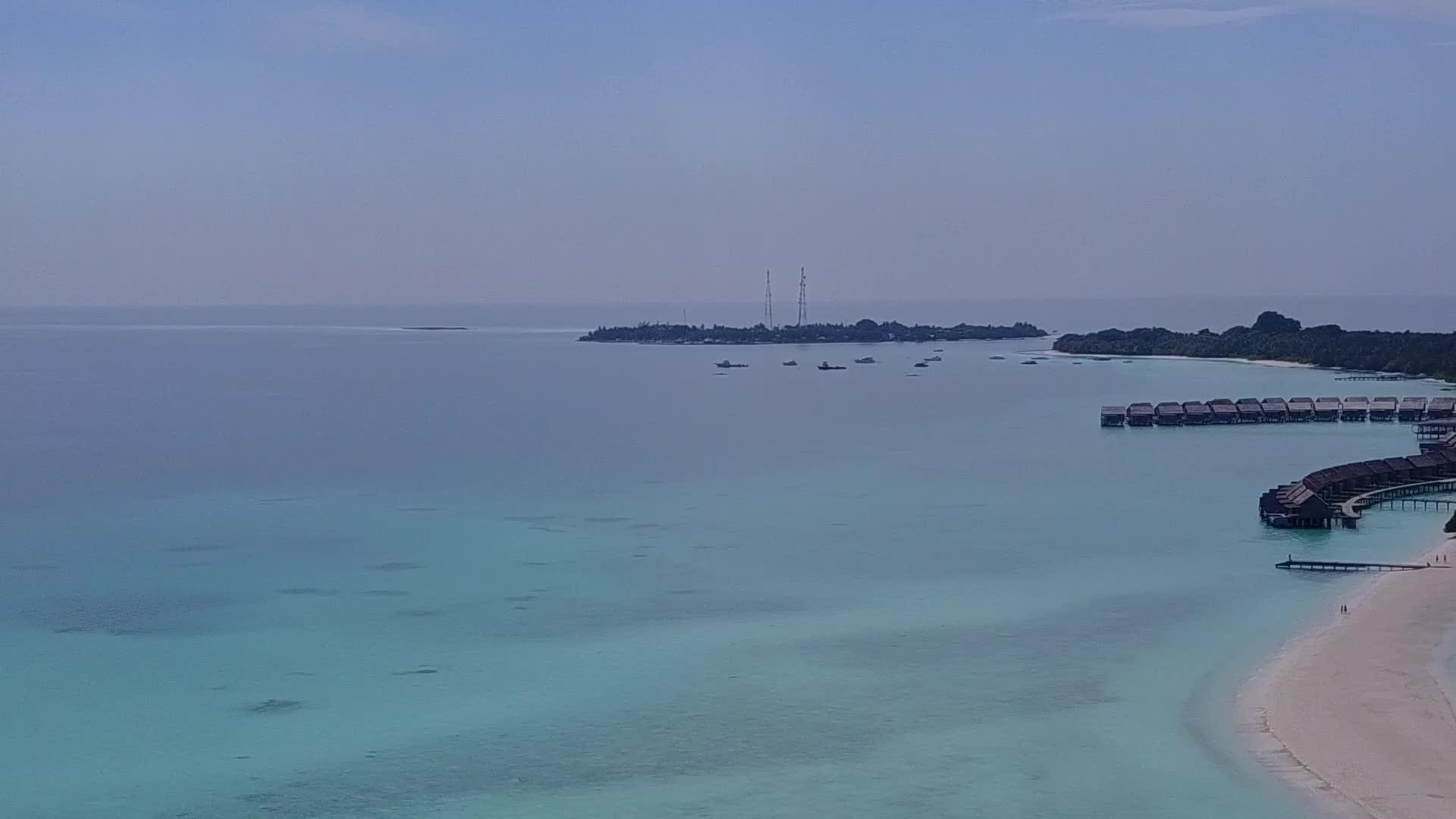 豪华环礁湖海滩蓝水和白色沙底蓝水在空中飞行视频的预览图
