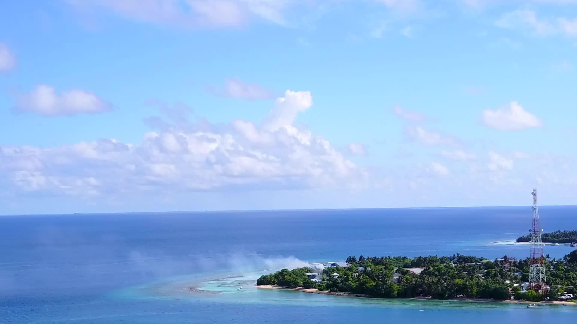 以白沙为背景的绿色海洋放松了环礁湖的无人驾驶时间视频的预览图