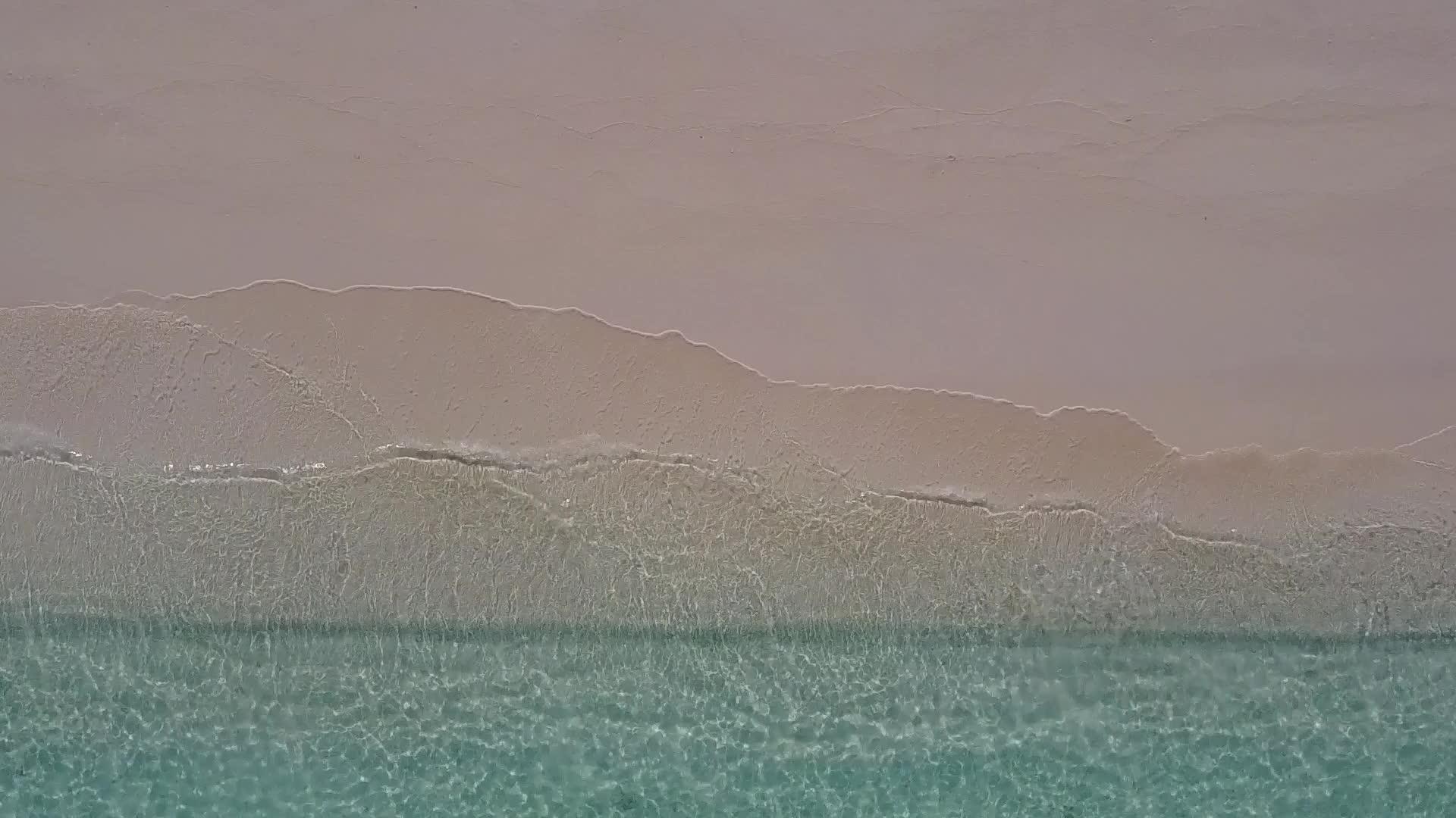 在白沙的背景下清澈的海洋和美丽的海岸海滩度假无人机视频的预览图