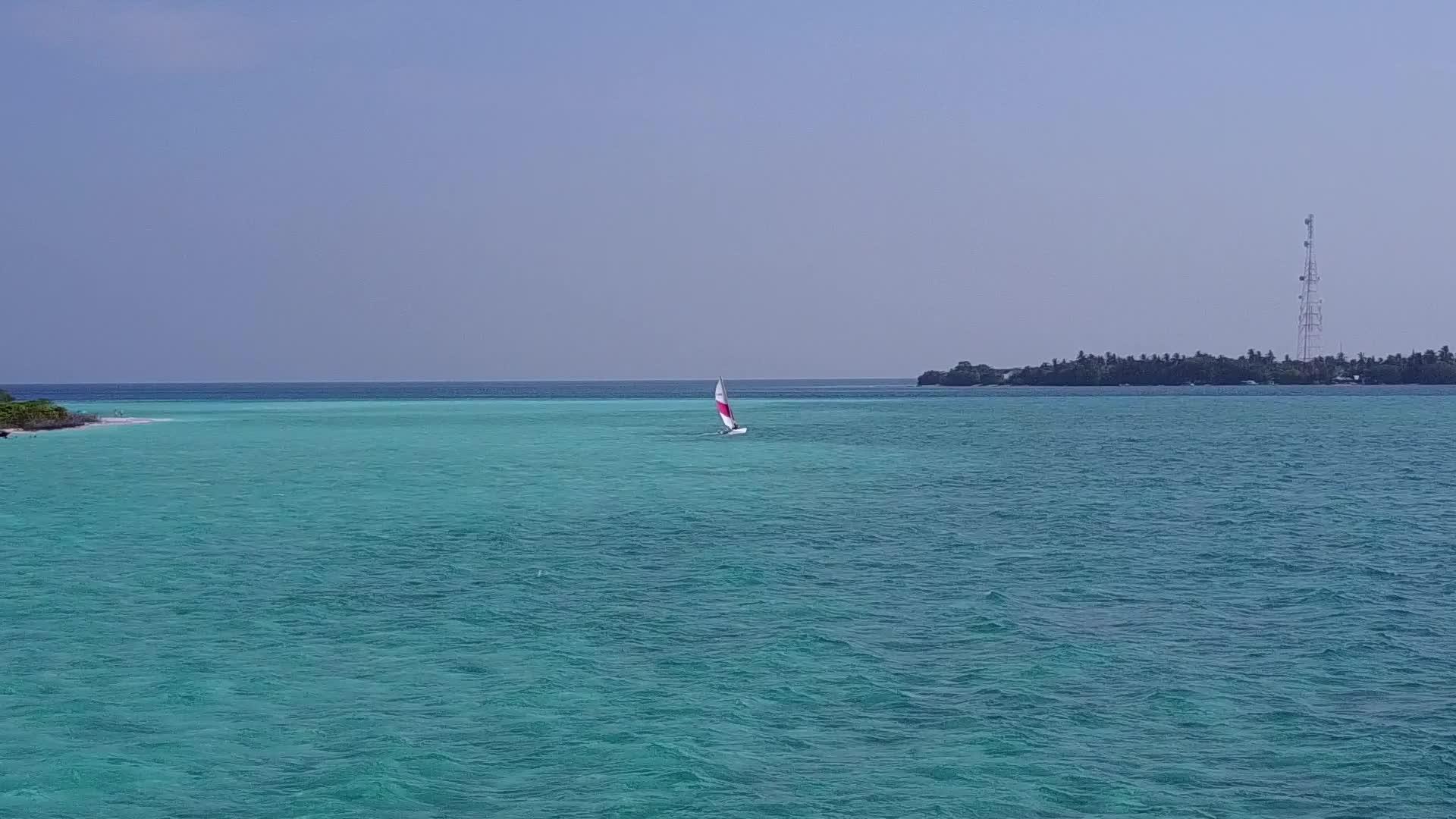 在蓝绿色海洋和干净沙质的背景下完美的海湾海滩度假空中无人机视频的预览图